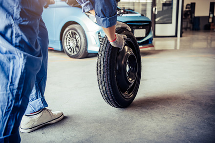 Car mechanics changing tire at auto repair shop garage. Transpor, an Industrial Photo by Ministocker