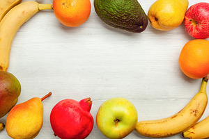 Frame of fresh fruit creating empty space on white wooden table, a Food & Drink Photo by Antonio Gravante Market