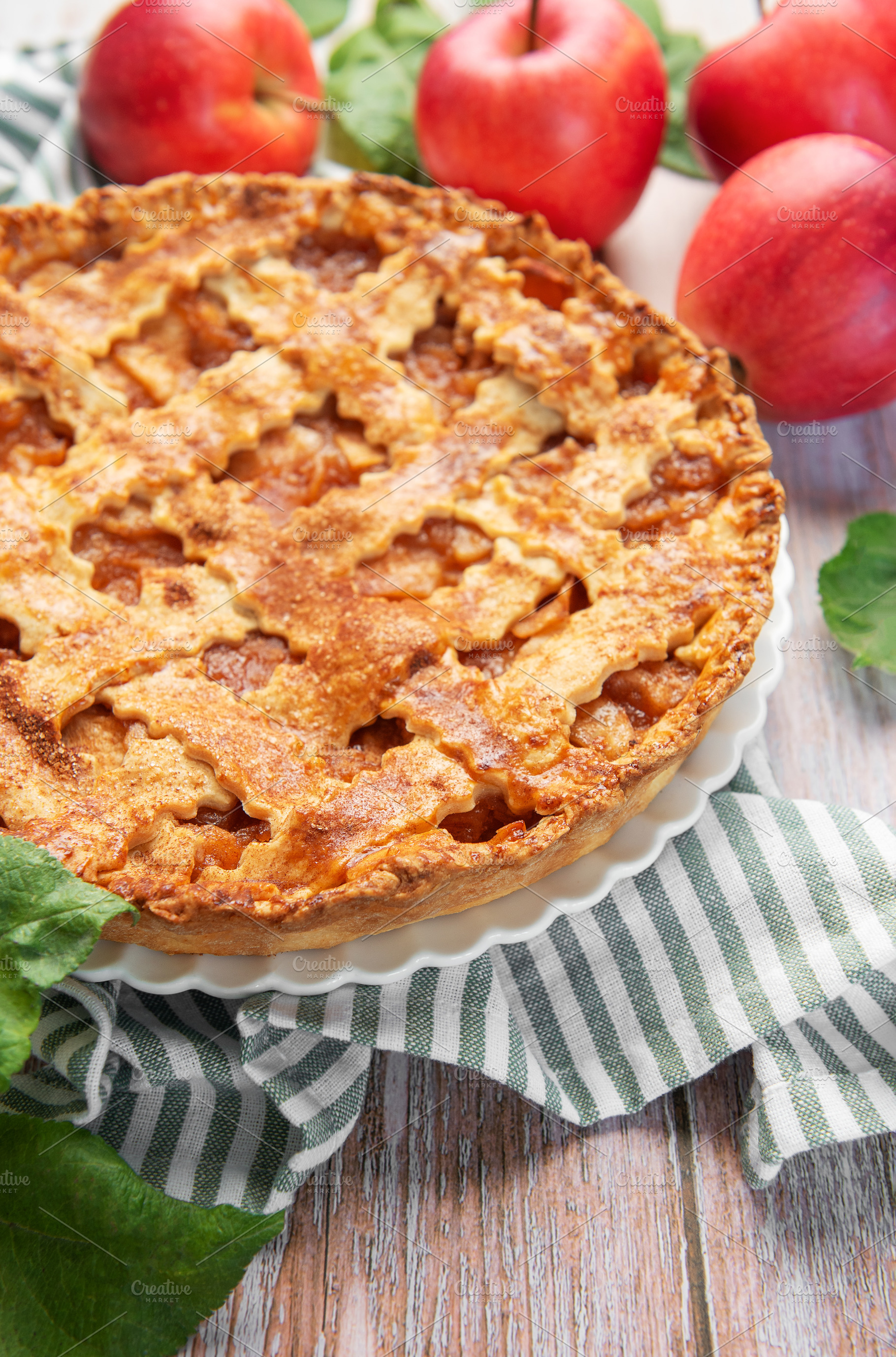 Freshly baked apple pie with red apples and leaves on rustic woo, a Food & Drink Photo by Olena Rudo
