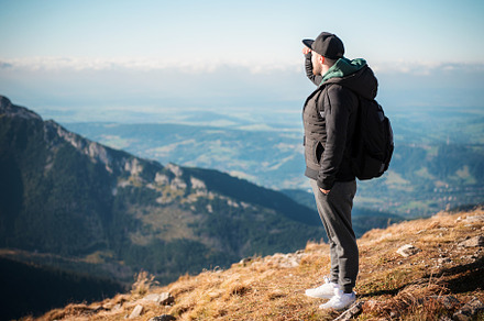 Young man  looking away in front of mountain on sunny day., a Person Photo by Olena Rudo