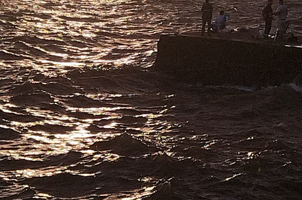People fishing at border of breakwater, montevideo, uruguay, a Photo by DanFLCreativo