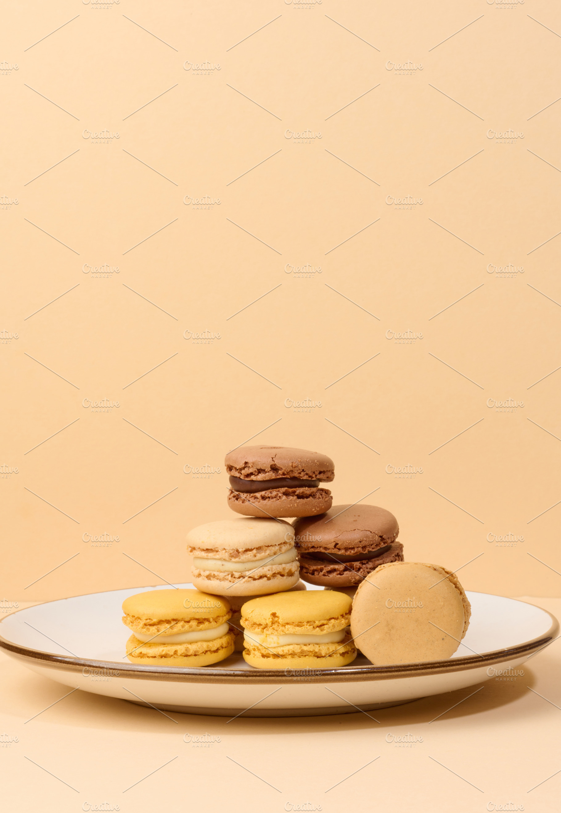 Multicolored almond macarons on a beige background, a Food & Drink Photo by ndanko