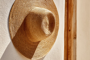 Sun-Drenched Straw Hat on a Wall, an Architecture Photo by Virgo Studio