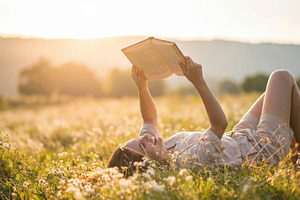 Woman Reading Book in Sunny Wildflower Meadow, a Photo by Davizro's Market