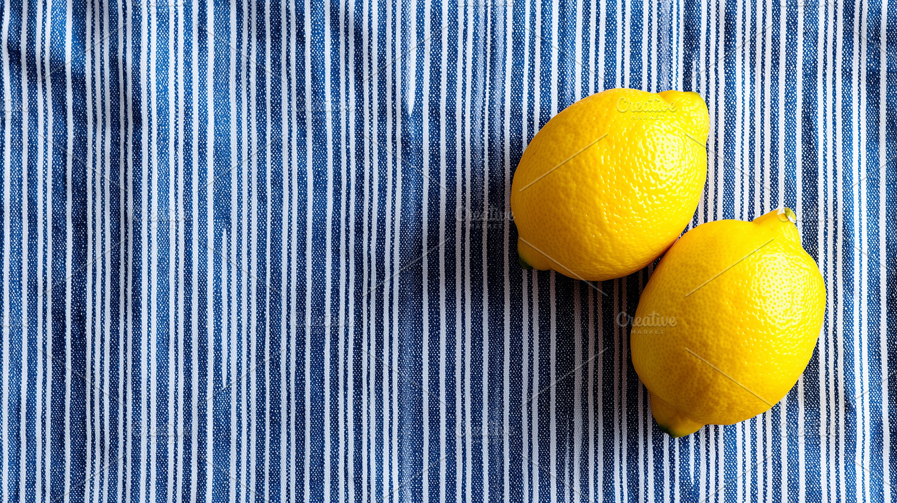 Two fresh yellow lemons on a blue, a Food & Drink Photo by MistyDay