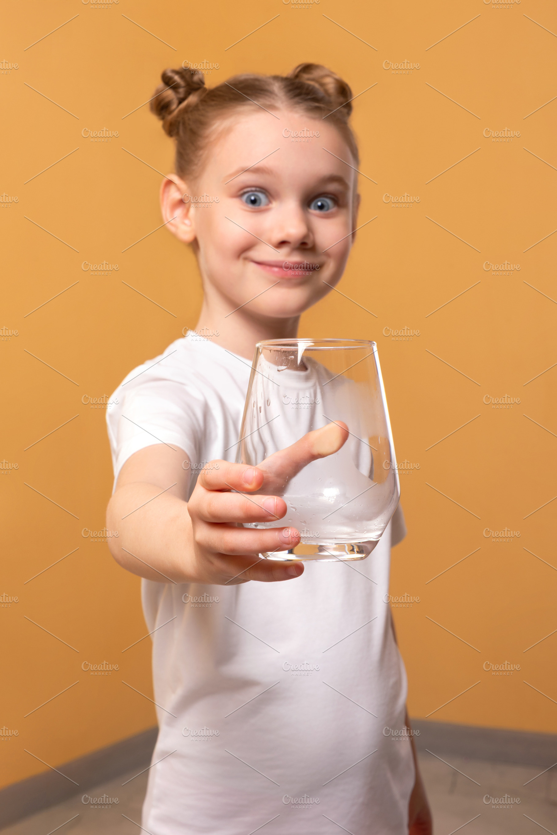 Happy young girl in white t-shirt extending an empty glass towar, a Person Photo by Ales Munt