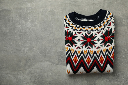 Knitted sweater on gray background, space for text, a Beauty & Fashion Photo by AtlasStudio PRO