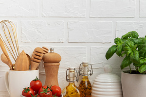 Kitchen countertop with cutting board, tomatoes, spices, and bas, a Food & Drink Photo by Olena Rudo