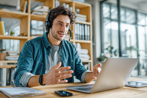 Man using laptop headset video confe, a Photo by Pixeness Studio