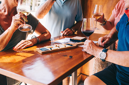 People eat cheese and drink wine in
