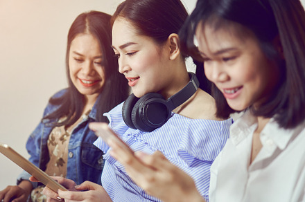 Asian girl and friend listening to music from black headphones and use laptop. In a comfortable and good mood, In the living room on the home., a Technology Photo by sitthiphong