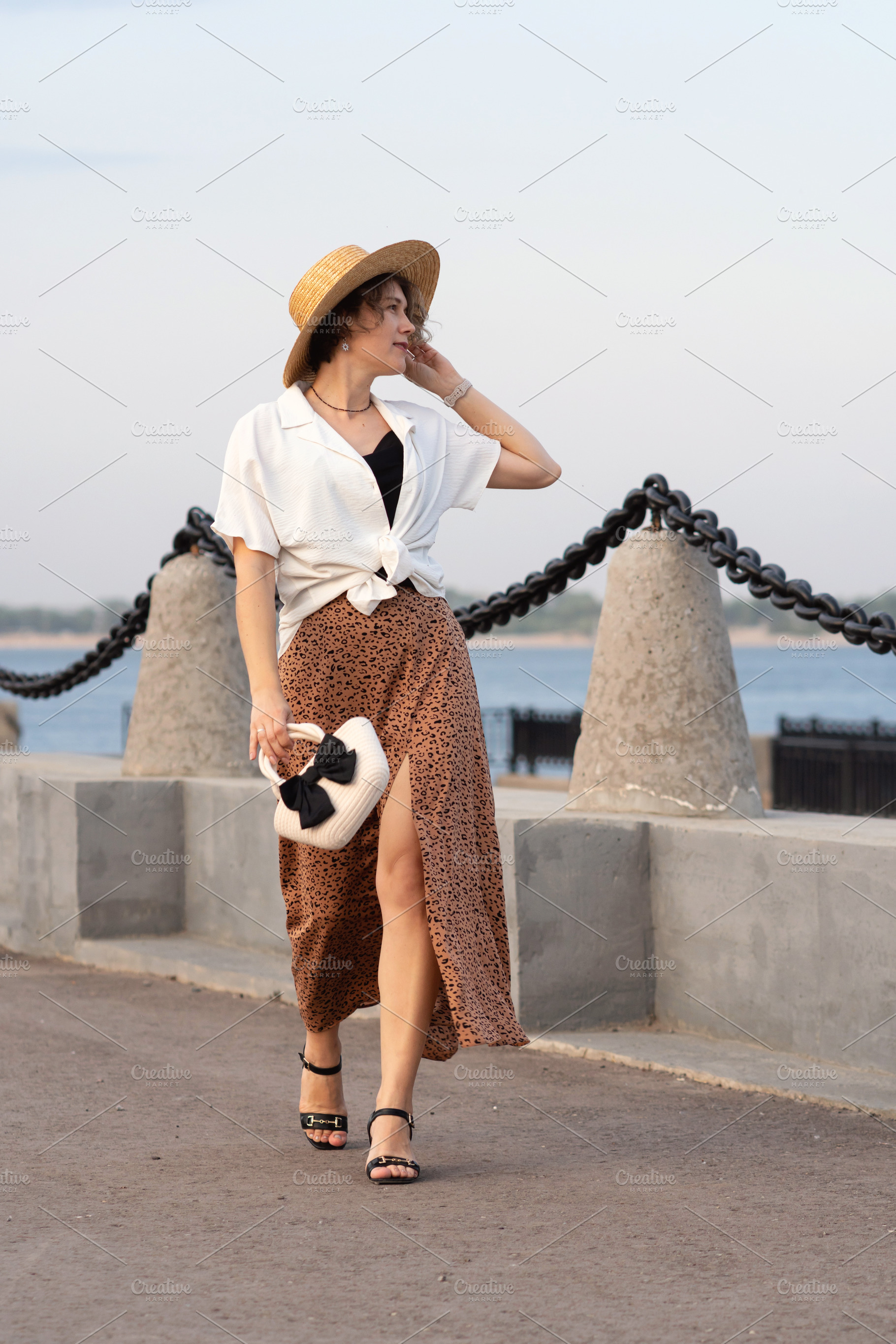 Woman walks stylishly holding hat, a Person Photo by Elena Vagengeim