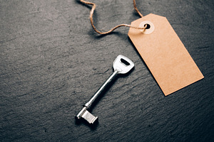 Key and blank kraft tag on slate, a Business Photo by Anna Efetova