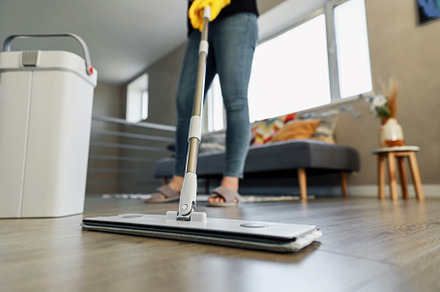 Woman mopping, wiping floor in modern home setting. Girl wearing yellow gloves, a Person Photo by Lenor4ik