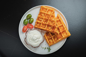 Crunchy waffle fries with sour cream dip served in a basket, a Food & Drink Photo by Budarinphoto