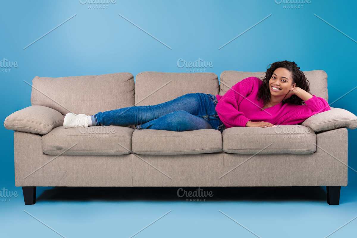 Beautiful happy young black woman in casual wear lying on sofa and smiling at c, a Photo by Prostock-Studio (Photo 1 of 2)