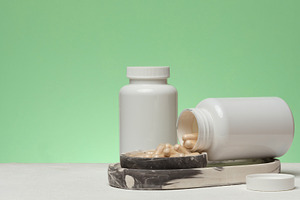 Two white plastic jars, one of which is overturned and capsules, a Health & Medical Photo by ndanko