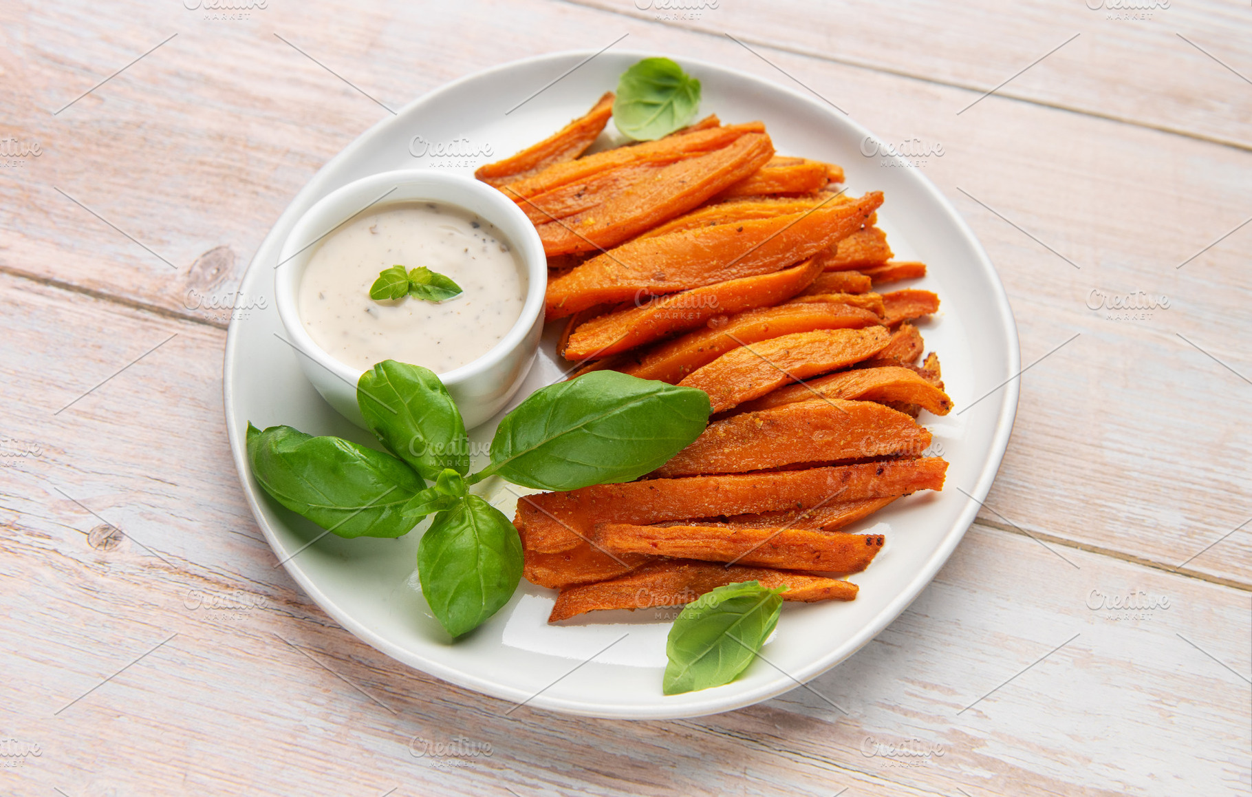 Sweet potato fries with dipping sauce and fresh basil, a Food & Drink Photo by Olena Rudo