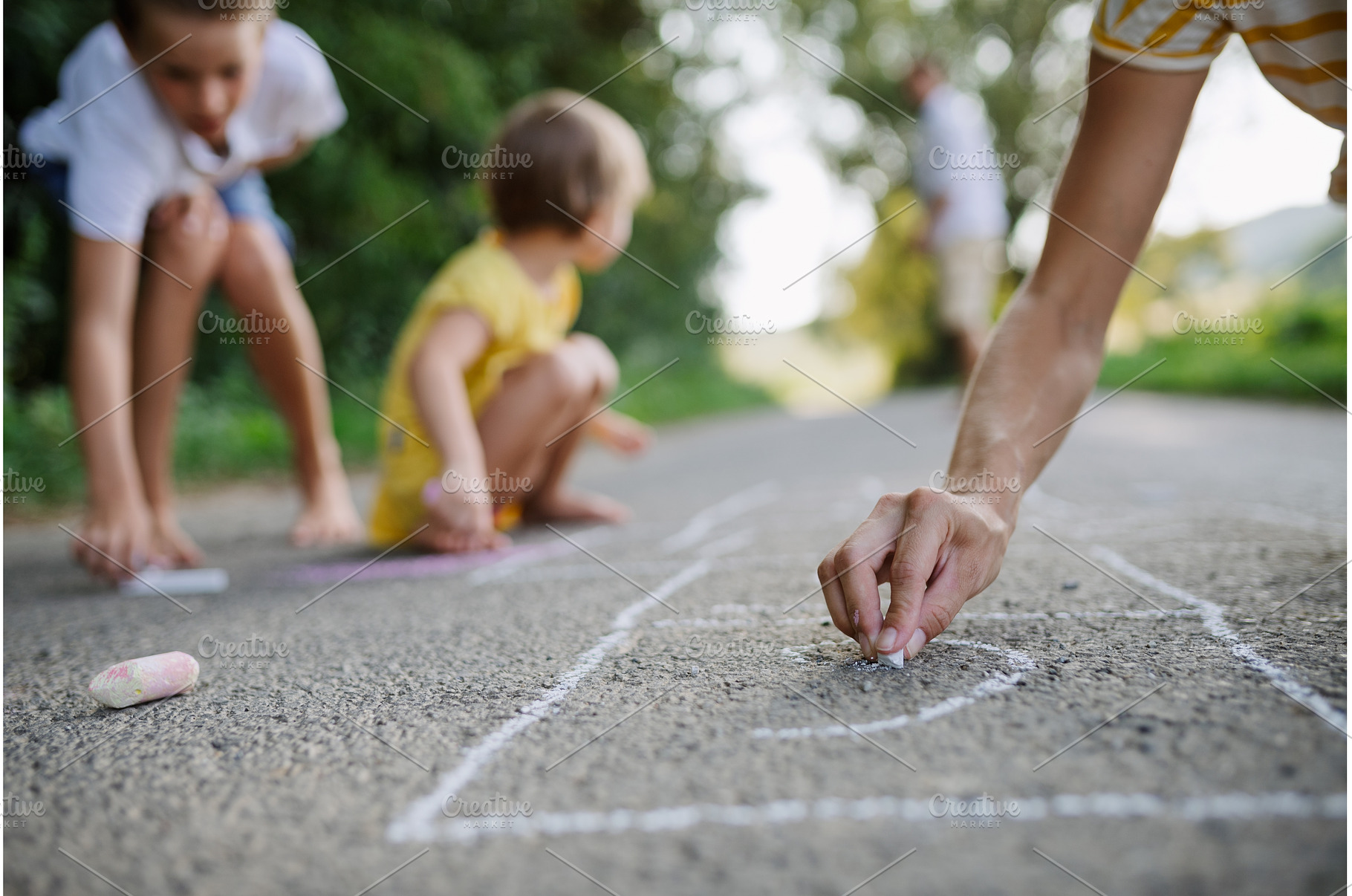 Mom and kids drawing with chalk on, a Person Photo by HalfPoint
