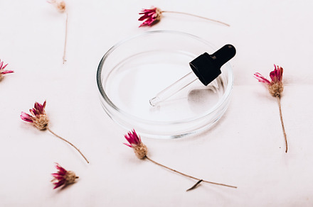 Abstract cosmetic medical background. Laboratory petri dish and dry flowers. Th