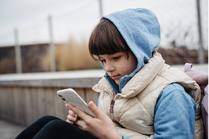 Girl sitting in front of school, a School & Education Photo by HalfPoint