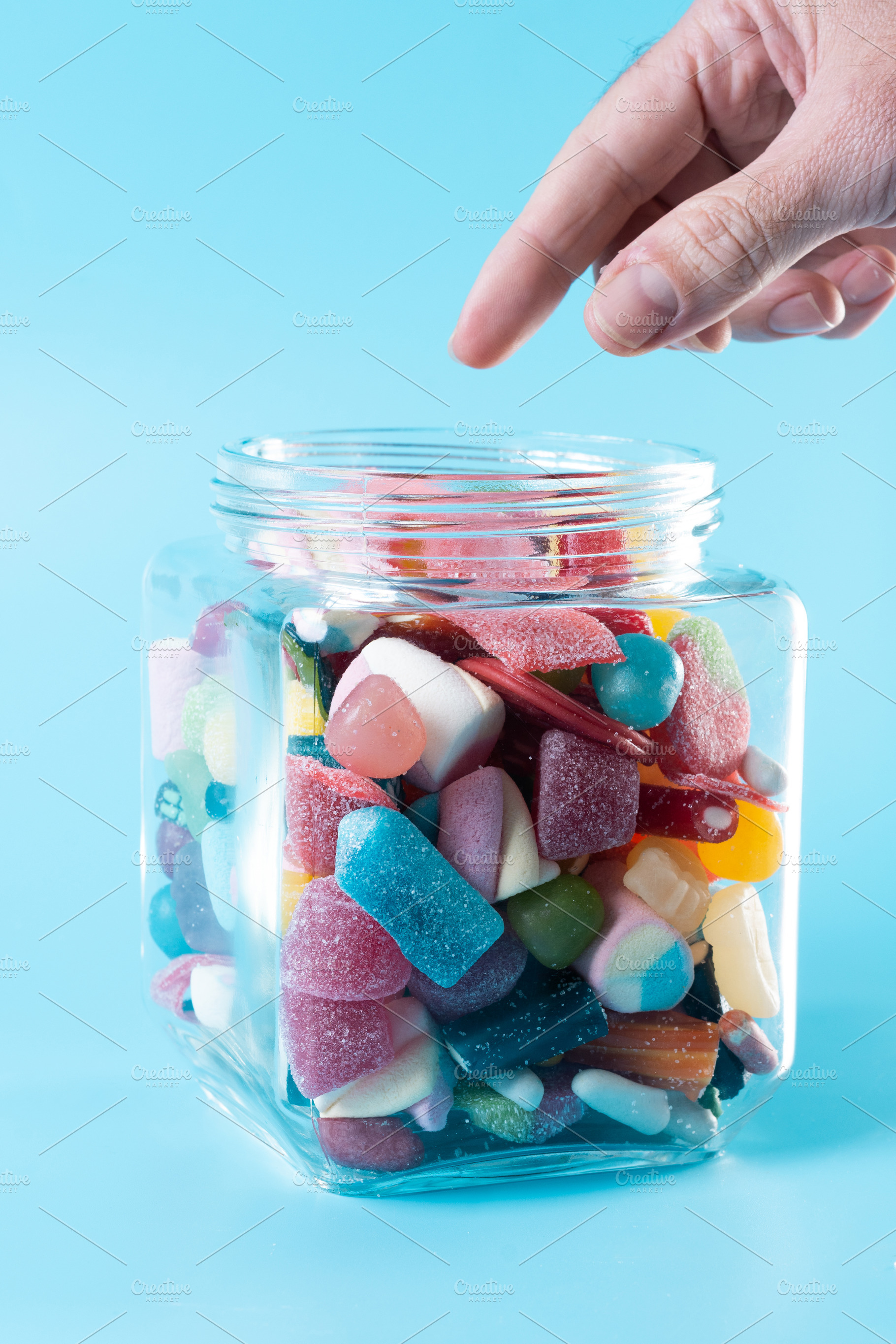Hand taking candy from glass jar, a Food & Drink Photo by etorres69