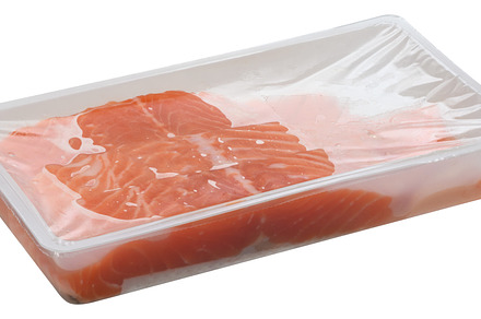 Slices of raw salmon fillets are packaged in a clear plastic tra, a Food & Drink Photo by ndanko
