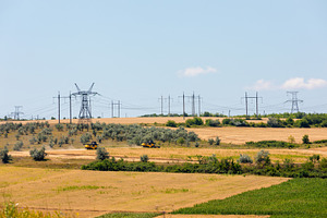 Two yellow combine harvesters working in a golden field under cl, an Industrial Photo by Ales Munt