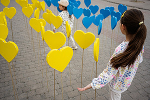 Two children exploring colorful ukrainian heart decorations in an urban outdoor, a Person Photo by AS photostudio
