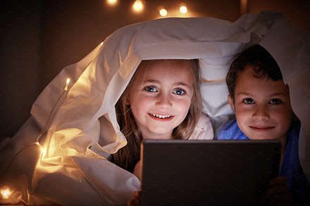 Portrait, evening and kids in bedroom, tablet and streaming movies with happiness, bonding and quality time. Face, children and siblings online games, blanket and cover with smile, technology and joy, a Photo by Peopleimages.com
