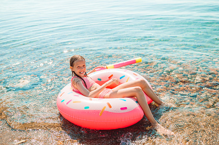 Adorable girl on inflatable air matt containing beach, vacation, and girl, a Person Photo by travnikovstudio
