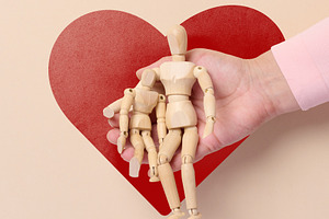 Wooden articulated figures in a person's open palm, with a large, a Holiday Photo by ndanko