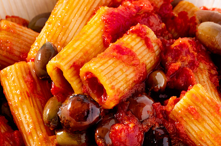 Italian tortiglioni pasta puttanesca with tomato sauce and black