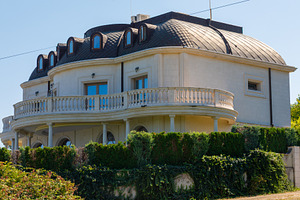 Luxurious stone mansion with rounded roof, arched windows, and ornate balcony,, an Architecture Photo by Ales Munt