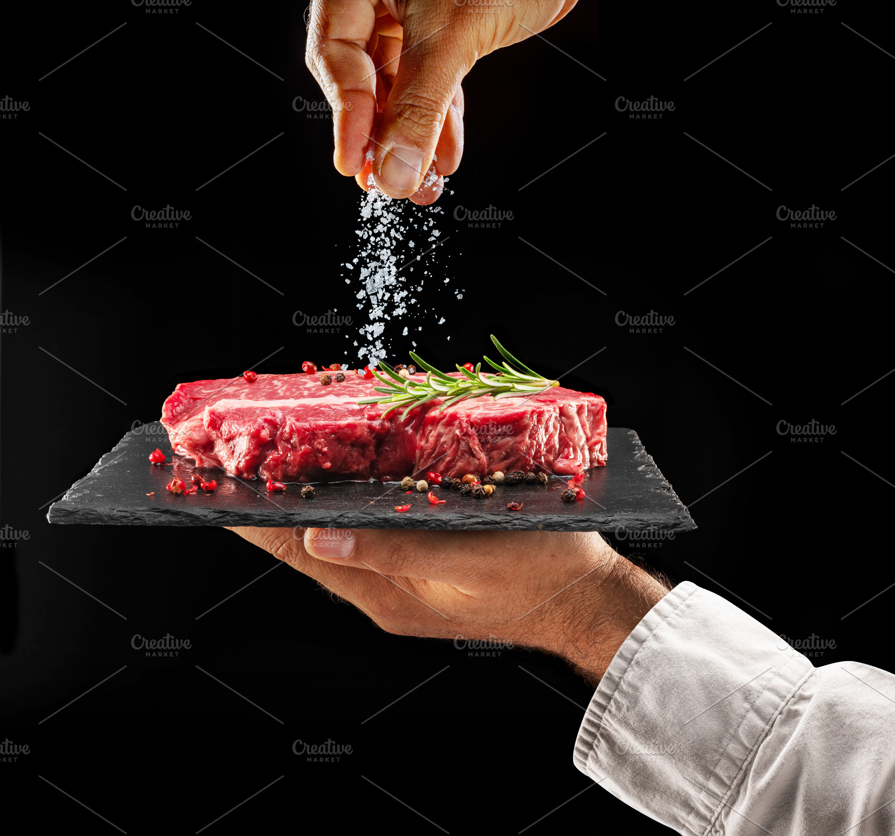 Chef is salting raw steak, a Food & Drink Photo by Volff