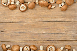 Champignon mushrooms on old wooden table.