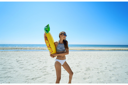 Happy beach woman holding inflatable, a Person Photo by vitaliymateha photography