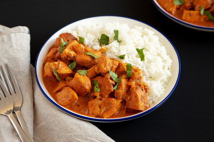 Homemade Easy Indian Butter Chicken with Rice on a Plate on a bl, a Food & Drink Photo by LiudmylaChuhunova