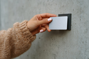 A close-up of a hand placing a white card against a sleek wall-mounted access p, a Business Photo by ImageMir