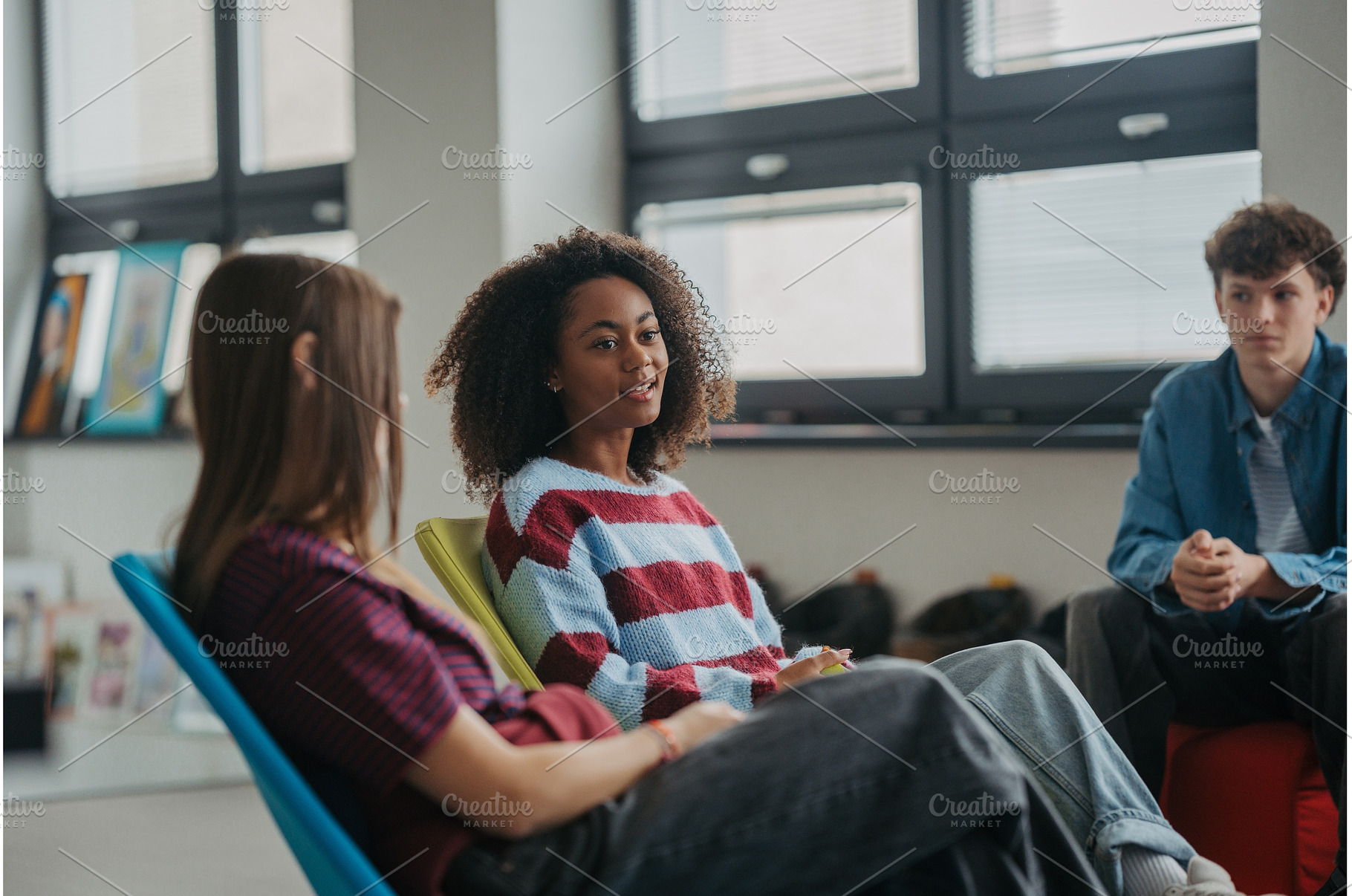 Classmates relaxing and talking in, a School & Education Photo by HalfPoint