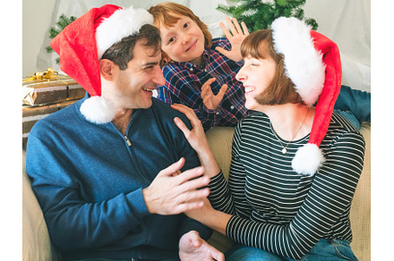 Mother, dad and son in santa caps on, a Holiday Photo by Lifemorning