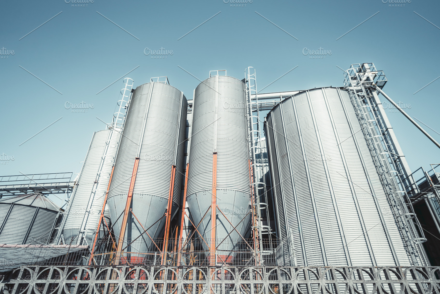 Grain silos under blue sky, an Industrial Photo by SkyNext