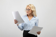 Serious businesswoman in formal wear and eyeglasses reading documents over ligh, a Photo by Prostock-Studio (Thumbnail 2 of 2)