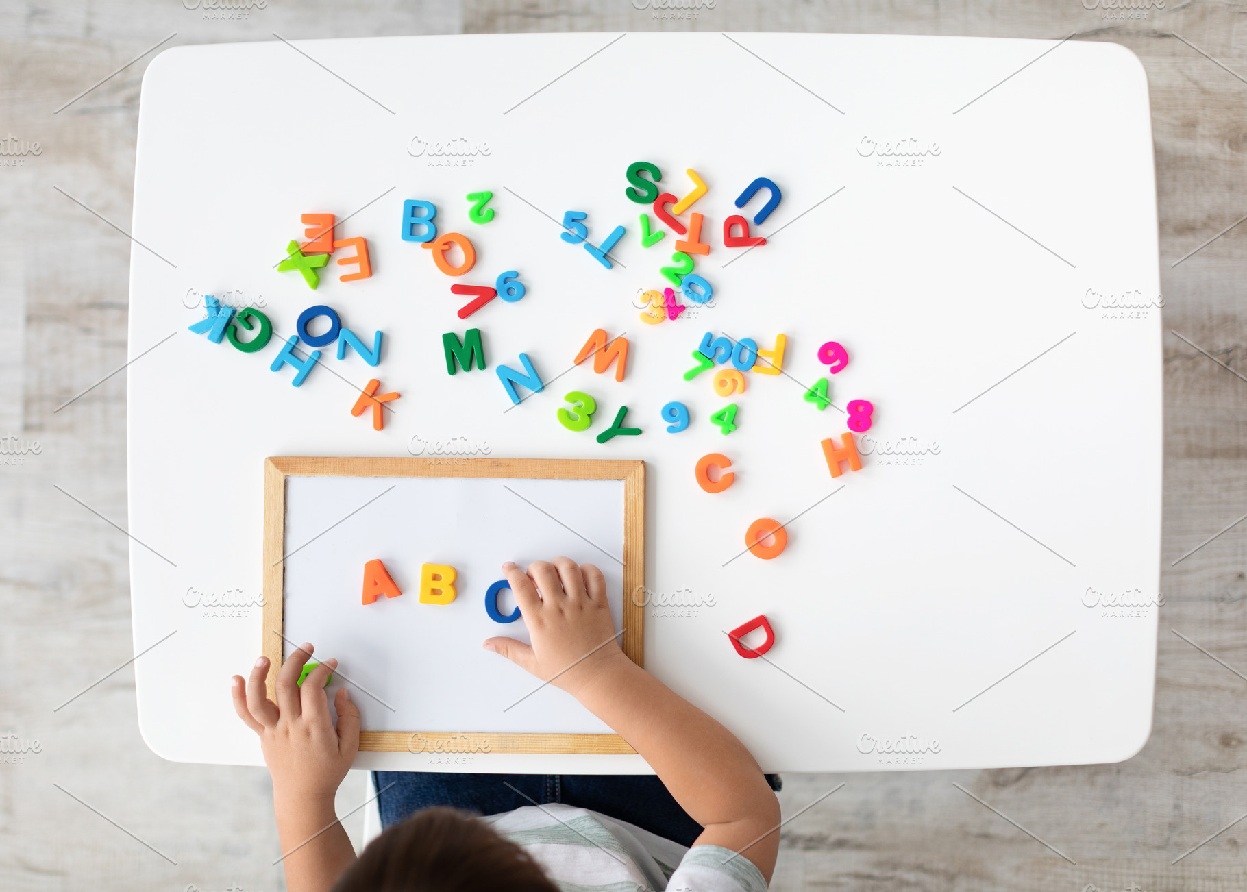 Foreign language classes. Top view of kid making ABC note with colorful English, a Photo by Prostock-Studio