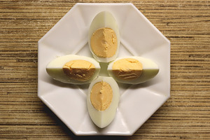 Four halves of hard-boiled eggs arranged on a white octagonal plate., a Food & Drink Photo by Textures & Backgrounds