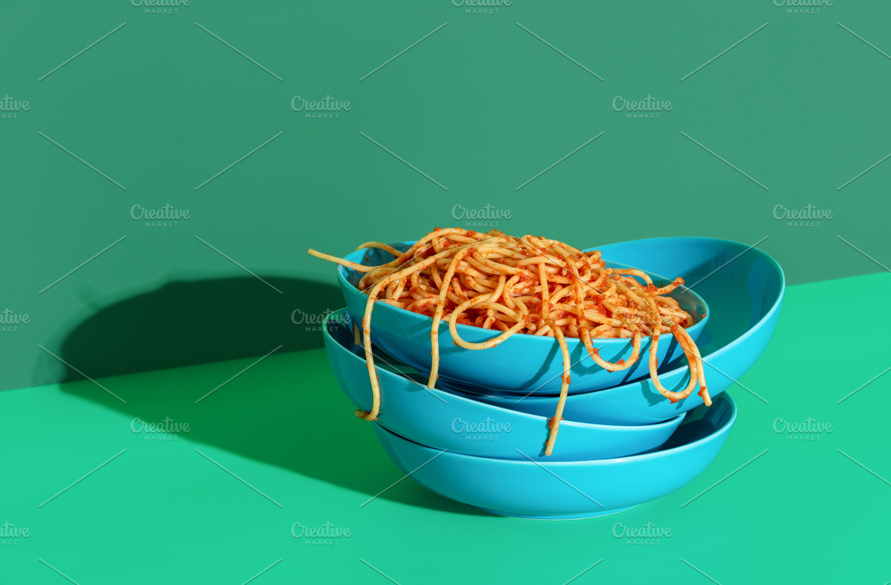 Spaghetti with tomato sauce minimalist on a green background, a Food & Drink Photo by YesPhotographers