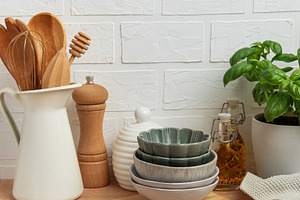 Kitchen utensils, bowls and spices resting on wooden countertop, a Photo by Olena Rudo