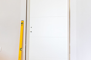 Carpenter Installing Modern White Door with Level and Hammer, an Architecture Photo by Antonio Gravante Market