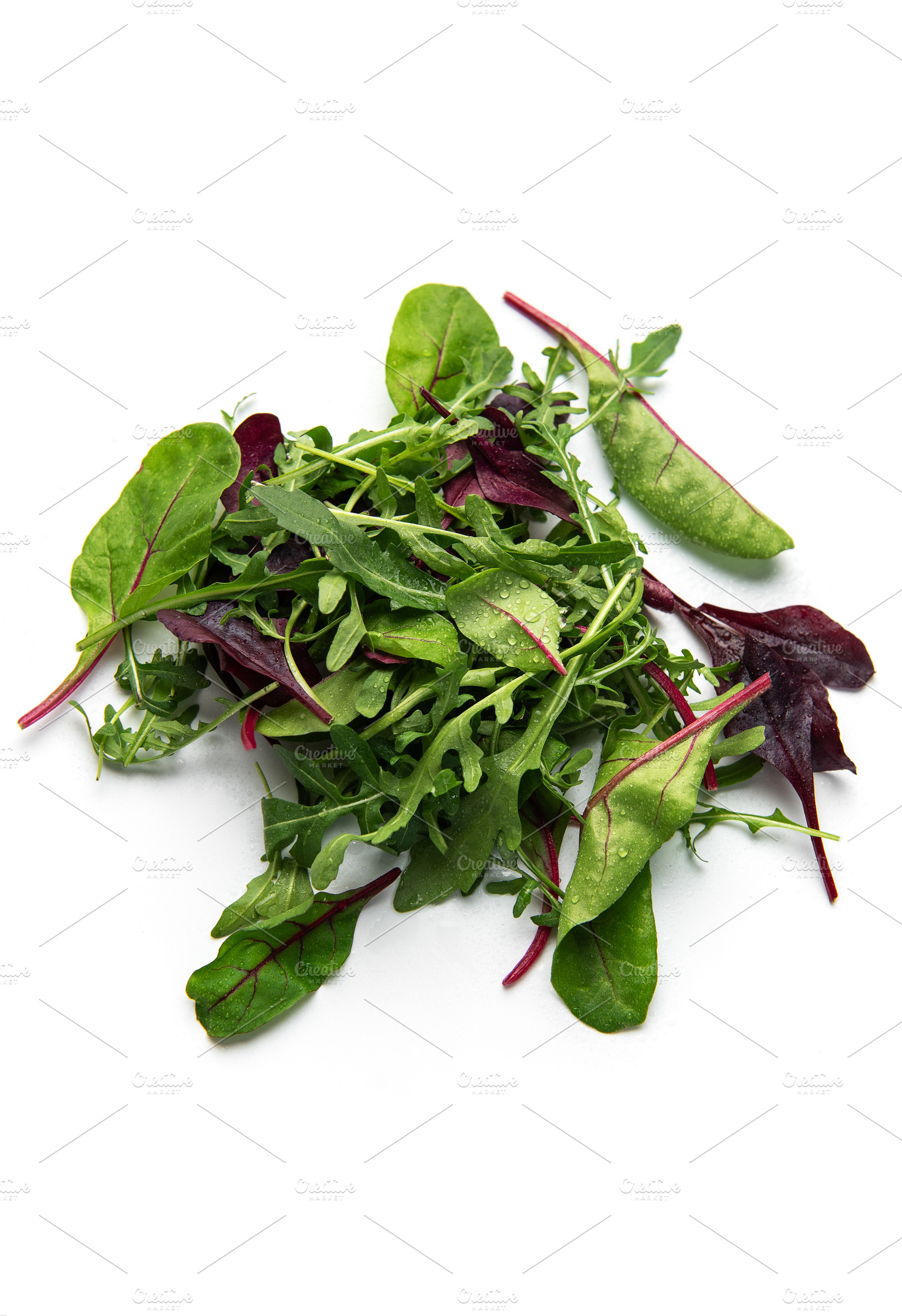 Fresh organic mixed greens salad pile on white background, a Food & Drink Photo by Olena Rudo