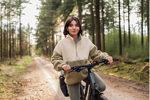Woman cycling through dense forest, a Holiday Photo by AD Stock Images